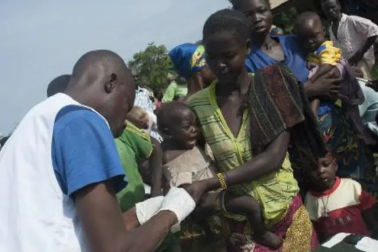 Membros da Médicos sem Fronteiras distribuem medicação para o combate da Malária (Andoni Lubaki/AFP)