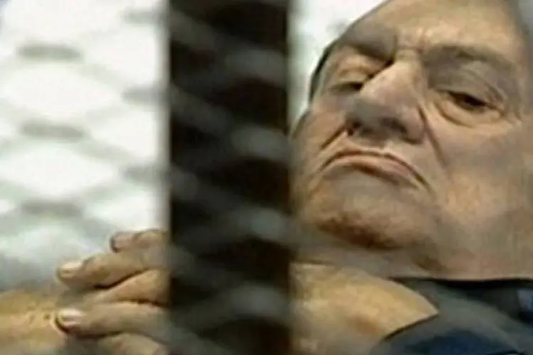 Imagem da televisão estatal egípcia mostra o ex-presidente Hosni Mubarak deitado em uma maca, ao dar entrada na sala de audiências (AFP)