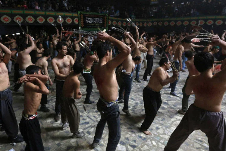 Muçulmanos durante ritual de flagelação em ocasião da Ashura, que recorda a morte do imã Hussein, neto de Maomé (Omar Sobhani/Reuters)