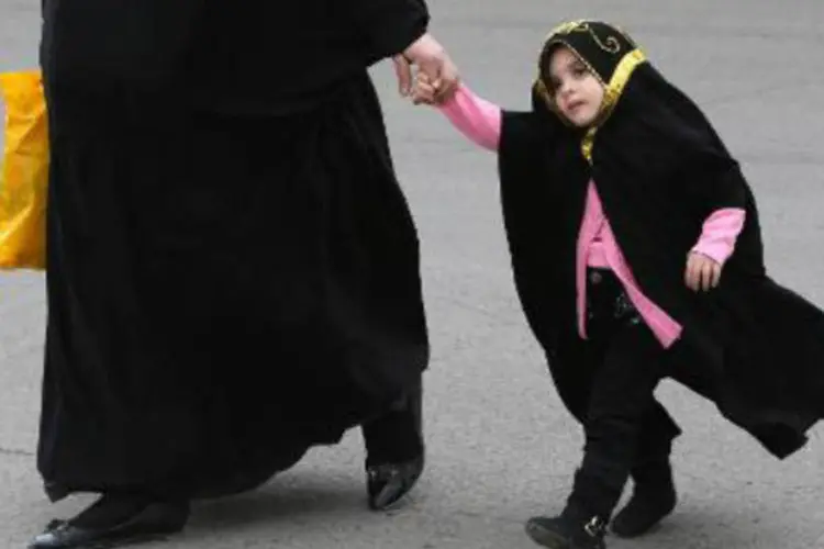 Mulher caminha com a filha em Bagdá: segundo analistas, projeto tem poucas chances de ser adotado (Ahmad Al-Rubaye/AFP)