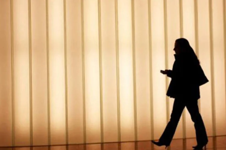 
	Mulher com celular: internet e mobile j&aacute; respondem por 58,5% das opera&ccedil;&otilde;es realizadas no sistema
 (AFP/Arquivo / Kimihiro Hoshino)