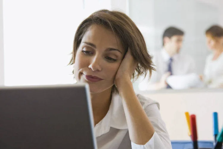 
	Mulher l&ecirc; algo em tela do computador no escrit&oacute;rio
 (Creatas Images/Thinkstock)