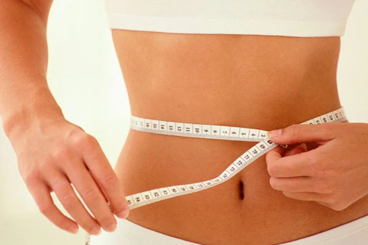 Mulher medindo a cintura (ThinkStock)