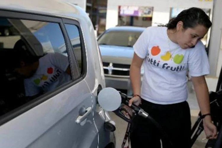 
	Mulher abastece carro em posto: venda ocorreu por por 2,6 bilh&otilde;es de d&oacute;lares
 (Joe Raedle/afp)