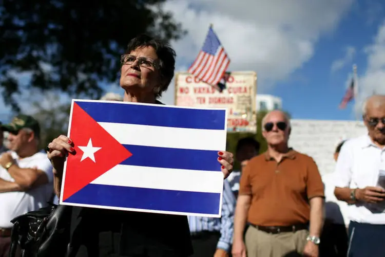 Mulher segura bandeira de Cuba em protesto nos Estados Unidos, no dia 20/12 (Getty Images)