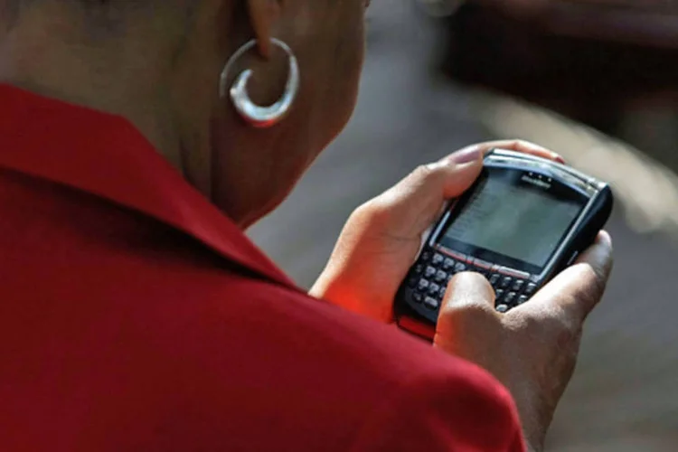 Mulher envia mensagem de celular (Getty Images)