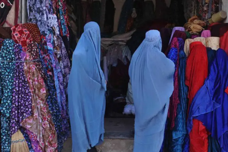 
	Mulheres afeg&atilde;s de burca diante de loja na prov&iacute;ncia de Herat: uma comiss&atilde;o registrou 4.010 casos de viol&ecirc;ncia contra mulheres entre abril e outubro de 2012
 (Aref Karimi/AFP)