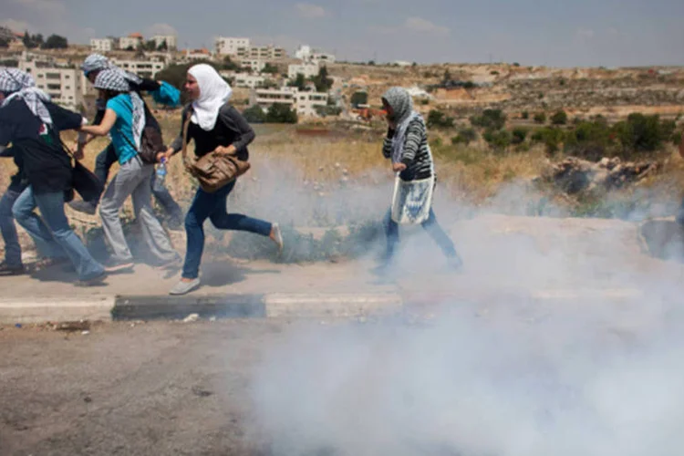 Mulheres palestinas fogem de bombas: Hollande e Hillary se encontraram na capital francesa depois da participação na reunião internacional de apoio à oposição síria (Uriel Sinai/ Getty Images)