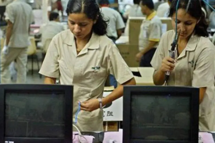 
	Mulheres trabalham em uma f&aacute;brica de computadores na Zona Franca de Manaus: um ter&ccedil;o da queda da pobreza foi motivado pelas mulheres com emprego, segundo o documento
 (Evaristo Sa/AFP/AFP)