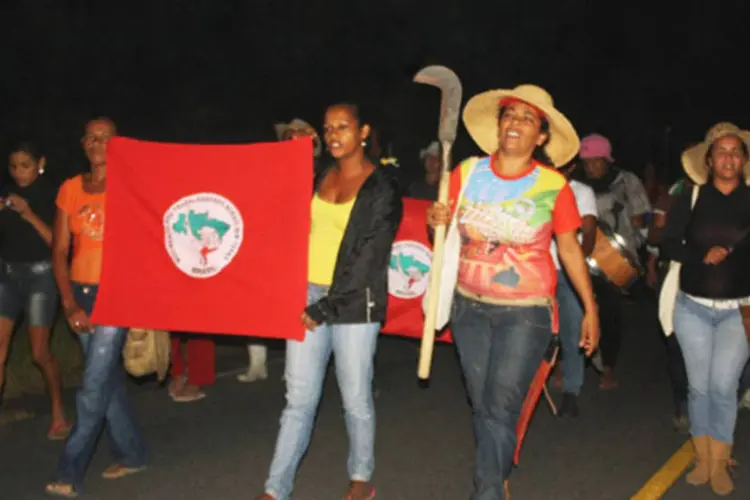 
	Mulheres carregam bandeira do MST: o n&uacute;mero de desaparecimento e assassinato &eacute; 3,5 vezes acima do total de reconhecidos como mortos por persegui&ccedil;&atilde;o pol&iacute;tica na ditadura
 (MST-BA/ Divulgação)
