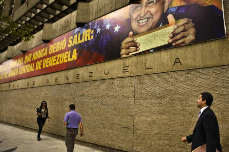 Mural do Banco Central da Venezuela mostra o ex-presidente Hugo Chávez com barras de ouro (Meridith Kohut/Bloomberg)