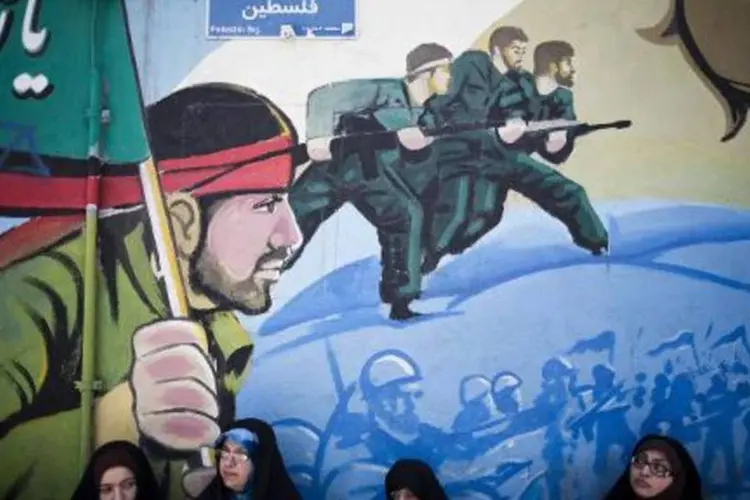Muro em uma praça de Teerã mostra uma pintura de soldados iranianos (Behrouz Mehri/AFP)