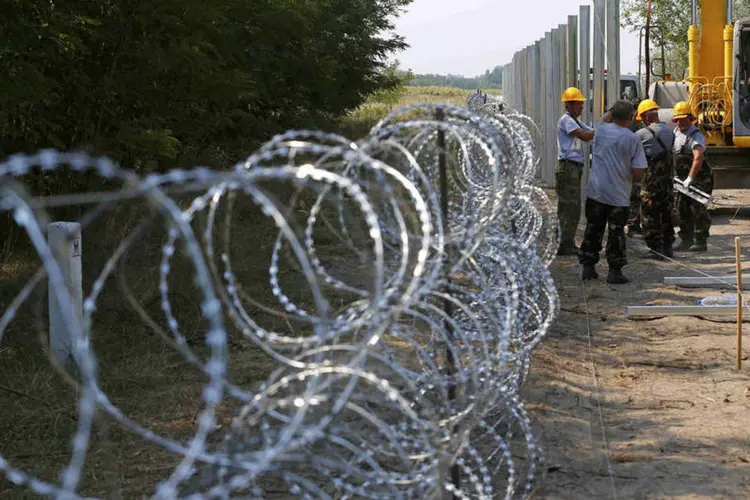 
	Muro para barrar entrada de imigrantes na Hungria: v&aacute;rios grupos de imigrantes foram parados pelos agentes e enviados de volta para o lado s&eacute;rvio da fronteira, indo rumo a uma regi&atilde;o florestal pr&oacute;xima, visivelmente desiludidos e resignados
 (Reuters / Laszlo Balogh)