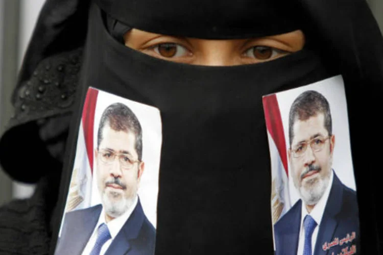 
	Mulher mostra fotos do presidente deposto Mohamed Mursi: durante os primeiros sete meses de transi&ccedil;&atilde;o, 90% das vitimas registradas eram civis
 (REUTERS/Mohamed al-Sayagh)