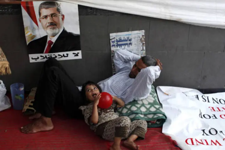 Criança descansa com seu pai em acampamento: fontes disseram que a polícia iria iniciar as ações contra os dois acampamentos para acabar com impasse que dura 6 semanas (Asmaa Waguih/Reuters)