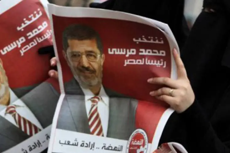 Partidárias de Mohamed Mursi leem jornal de campanha no Egito (©AFP / Patrick Baz)