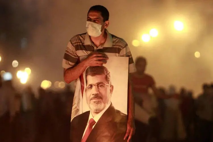 Manifestante favorável ao presidente egípcio deposto, Mohamed Mursi, carrega pôster de Mursi:  (Reuters)