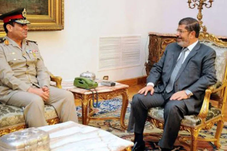 Mohamed Mursi (D), se encontra com o novo ministro da Defesa: a imprensa egípcia descreveu como "revolucionárias" essas decisões (©AFP / Ho)