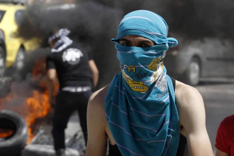 Nakba: cerca de duzentos manifestantes agitavam bandeiras e atiravam pedras no local (Ammar Awad/Reuters)