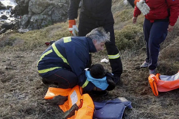 
	Resgate: bombeiro grego carrega o corpo de um menino ap&oacute;s naufr&aacute;gio que carregava refugiados e imigrantes
 (Reuters Media)