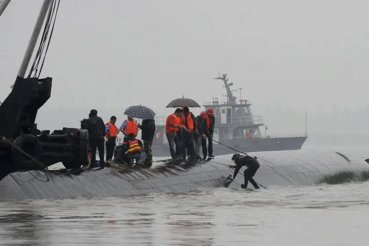 
	Buscas em navio na China: as equipes ter&atilde;o que decidir entre tentar desvirar o navio, que tombou; arrast&aacute;-lo at&eacute; a margem, muito pr&oacute;xima; ou come&ccedil;ar a perfurar a quilha, que ainda sobressai na &aacute;gua
 (REUTERS/China Daily)