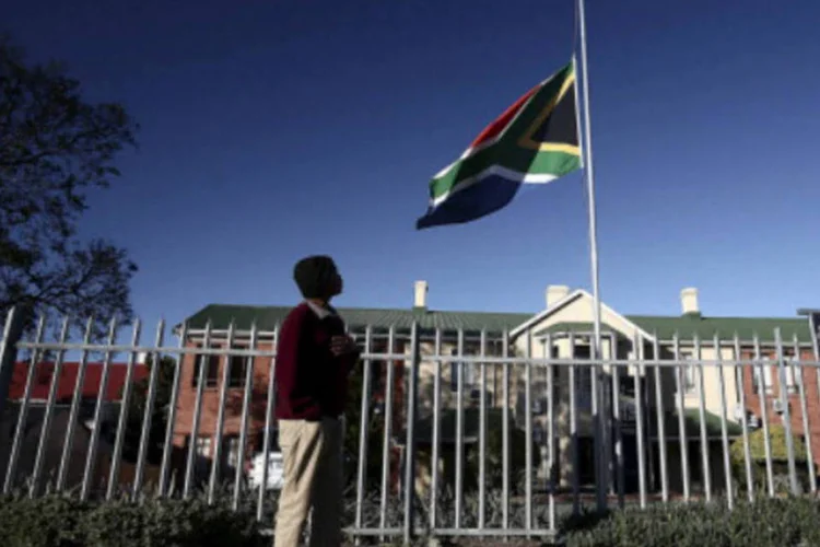 
	Homem observa a bandeira do pa&iacute;s a meio mastro, em homenagem ao l&iacute;der Nelson Mandela: os preparativos para o funeral tamb&eacute;m come&ccedil;am
 (Mark Andrews/Daily Dispatch/Gallo Images/Getty Images)
