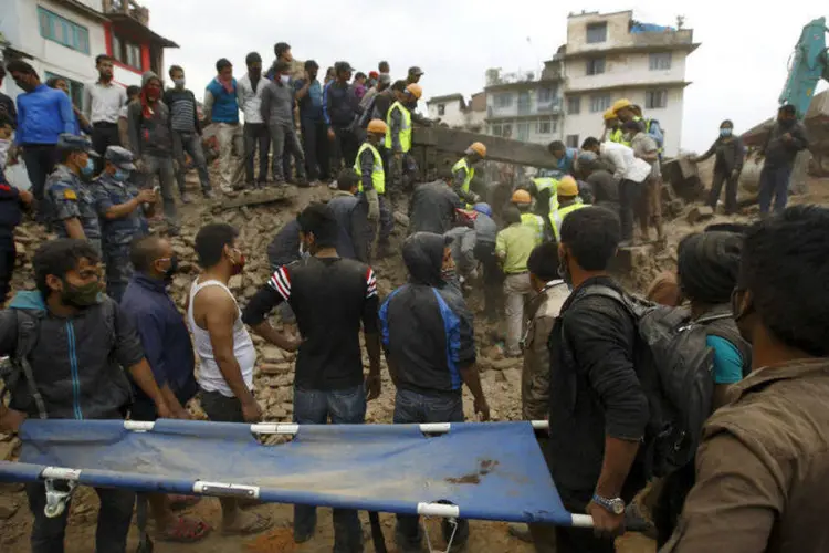 
	Equipes de resgate usam macas e vasculham os escombros para achar sobreviventes e corpos, ap&oacute;s terremoto no Nepal
 (Reuters)