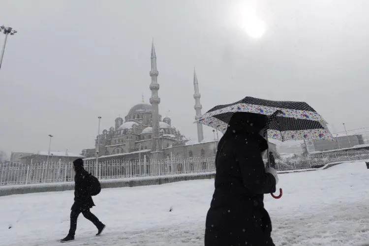 Pessoas caminham durante nevasca diante de mesquita em Istambul (Murad Sezer/Reuters)