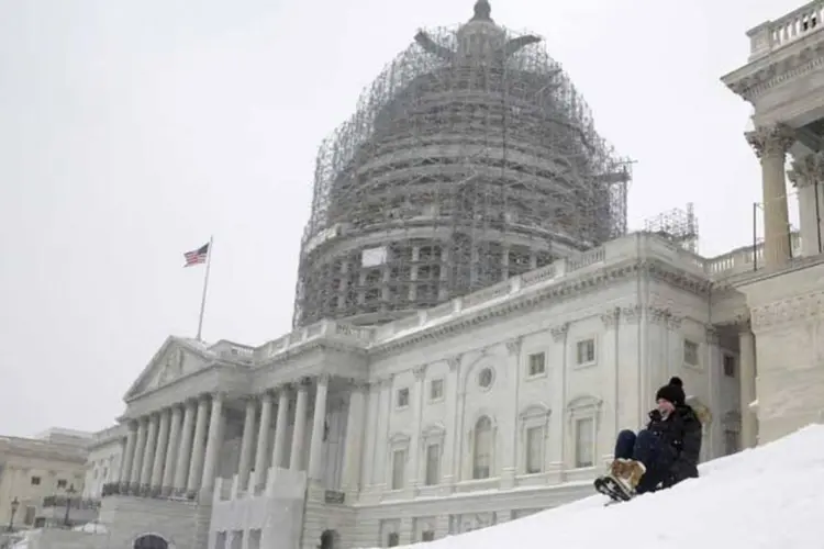 
	Mulher brinca de deslizar sobre a neve que se acumula nas escadas do Capit&oacute;lio dos EUA, em Washington, em janeiro: tempestade cancelou mais de 1.500 voos
 (Reuters)