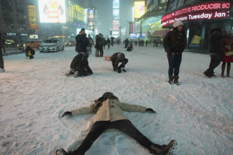 
	Mulher faz um anjo de neve na Times Square, em Nova York: em mais de duas d&eacute;cadas, o Servi&ccedil;o Meteorol&oacute;gico Nacional n&atilde;o registrou temperaturas t&atilde;o baixas
 (REUTERS/Carlo Allegri)