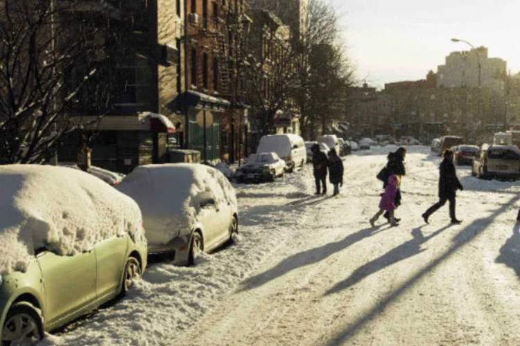 Pais levam crianças para a escola em rua do Brooklyn, em Nova York: nevasca não causou transtornos de grande importância (Lucas Jackson/Reuters)