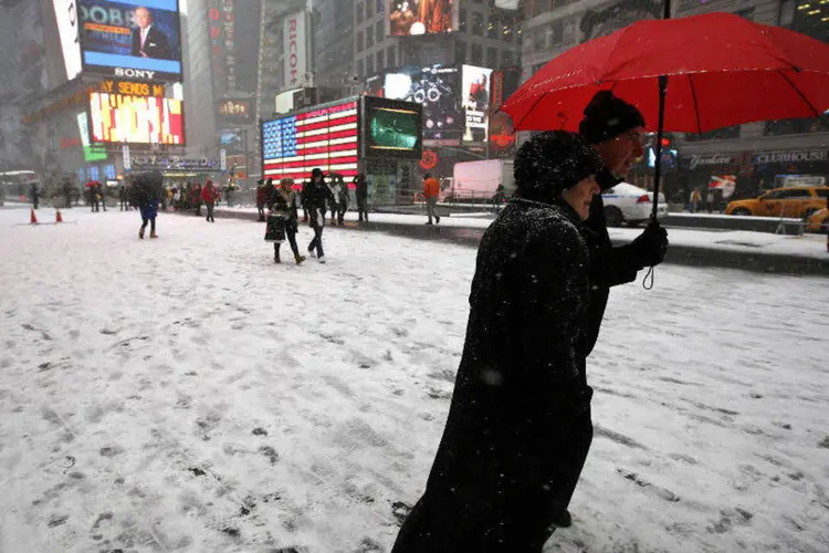 
	Pessoas caminham pela Times Square, em Nova York, enquanto neve cai
 (Mike Segar/Reuters)