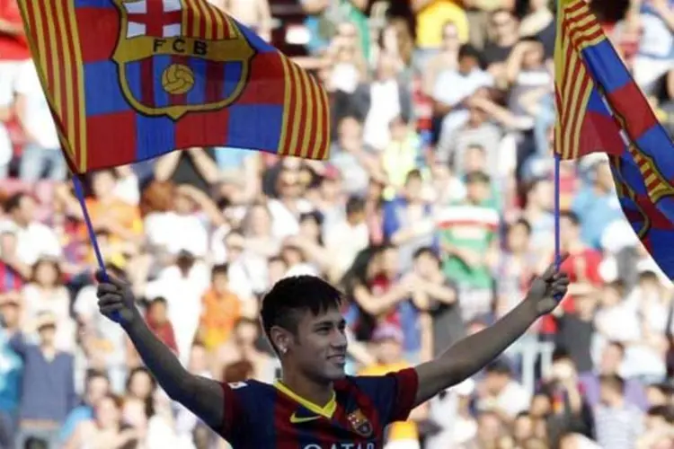 Neymar agita bandeiras do Barcelona em sua apresentação ao clube espanhol (Gustau Nacarino / REUTERS)