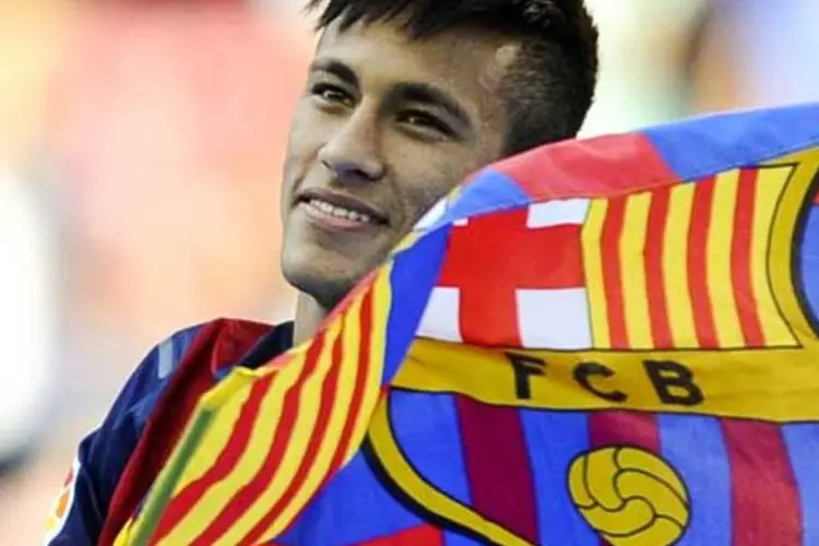 
	Neymar segura a bandeira do Barcelona duranteb sua apresenta&ccedil;&atilde;o no time espanhol
 (Getty Images)