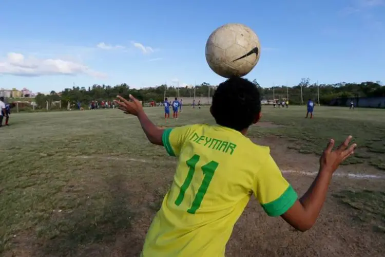 Copa do Mundo: menino vestido com camiseta do Neymar equilibra bola na cabeça durante  (REUTERS/Edison Vara)