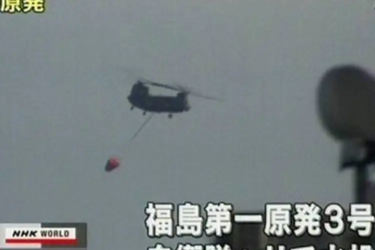 Helicópteros começaram a jogar água nos reatores superaquecidos e as autoridades disseram que cabos de energia poderiam ser ligados nesta tarde  (Reprodução/NHK)