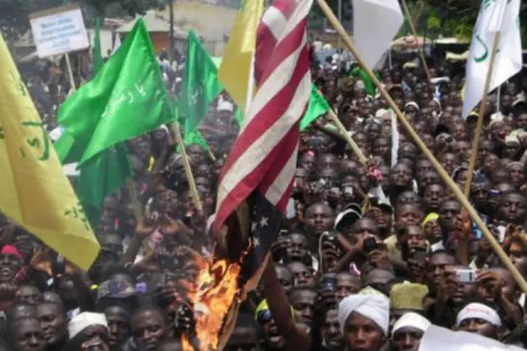 
	Manifestantes queimam bandeiras americanas na cidade nigeriana de Kaduna durante um protesto nesta segunda
 (Victor Ulasi/AFP)