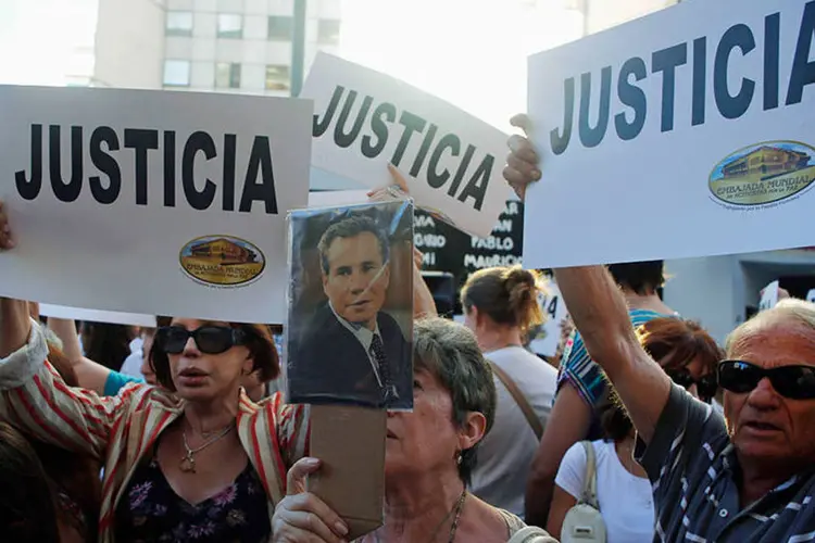 
	Mulher segura fotografia de Alberto Nisman em frente a centro judaico durante protesto
 (REUTERS/Marcos Brindicci)