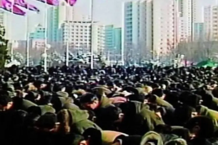 Multidão observa um minuto de silêncio pela morte do líder norte-coreano, no dia 29 de dezembro de 2011 (North Korean Tv/AFP)