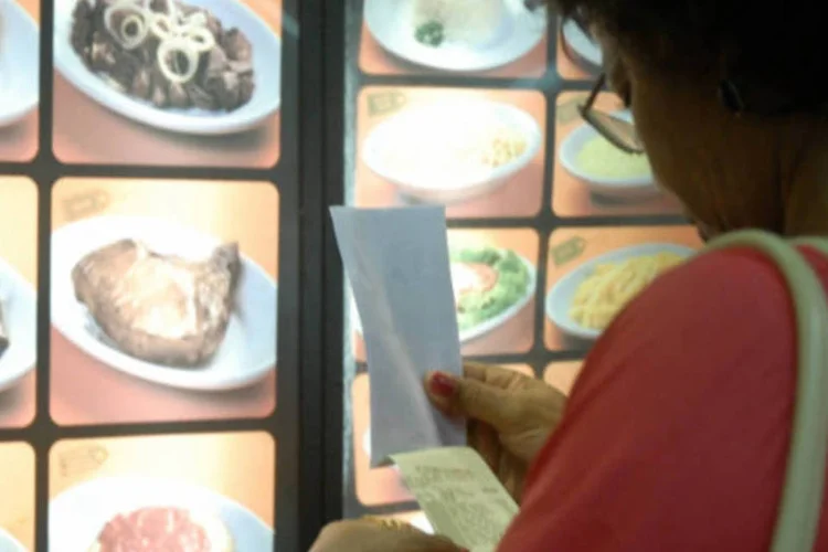 
	Consumidora checa a nota fiscal enquanto aguarda o almo&ccedil;o: segundo o relat&oacute;rio, entre os seis setores analisados, o avan&ccedil;o foi maior em &quot;outros servi&ccedil;os&quot; e hot&eacute;is e restaurantes
 (Tânia Rego/ABr)