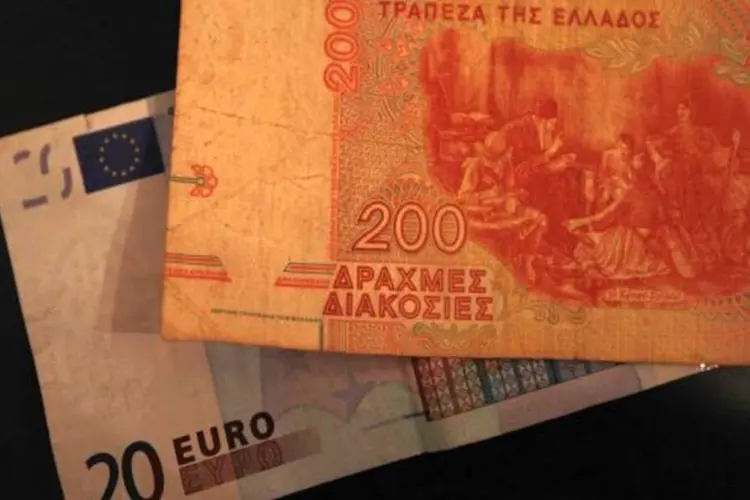 nota de euro e de dracma: Se a Grécia não abandonar o euro, ela, provavelmente, não vai conseguir voltar a crescer, segundo Amorim (Getty Images)