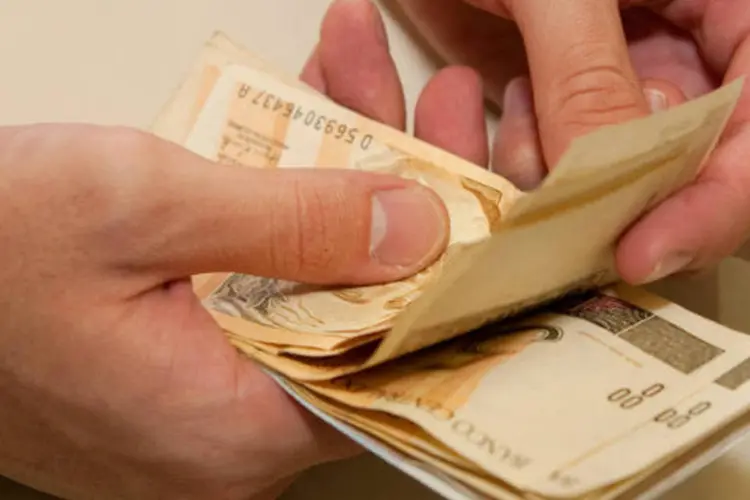 Dinheiro: pessoa conta notas de real (Marcos Santos/USP Imagens)