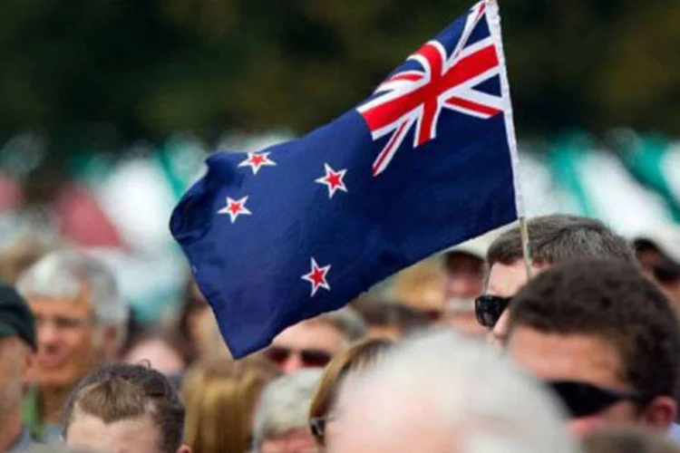 
	Um homem segura a bandeira da Nova Zel&acirc;ndia: eleva&ccedil;&atilde;o ocorre na medida em que a expans&atilde;o econ&ocirc;mica do pa&iacute;s ganha for&ccedil;a e as press&otilde;es inflacion&aacute;rias crescem
 (Marty)