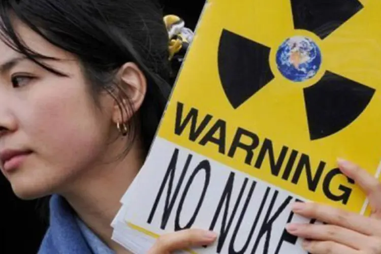 Manifestante segura cartaz em protesto contra a energia nuclear em frente à Tokyo Electric Power (Tepco), em Tóquio (Toru Yamanaka/AFP)
