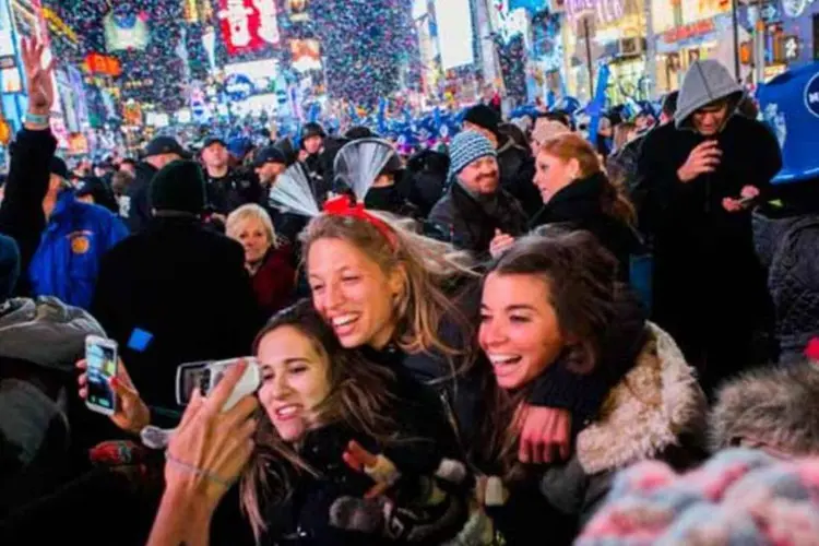 
	Americanos durante festa na Times Square, Nova York:&nbsp;n&uacute;mero total de US$ 80,7 trilh&otilde;es &eacute; um recorde hist&oacute;rico, de acordo com Fed
 (Getty Images)