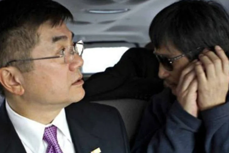 O dissidente chinês Chen Guangcheng conversa ao telefone ao lado embaixador americano na China, Gary Locke (E) (US Embassy Beijing Press Office/AFP)