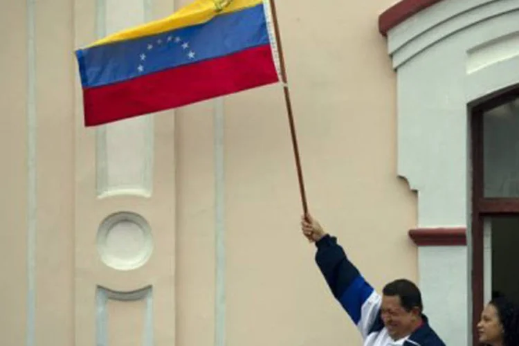 Hugo Chávez segura bandeira: para Chávez, o Mercosul é a oportunidade para os pequenos e médios produtores exportarem para os países da região (©AFP / Juan Barreto)