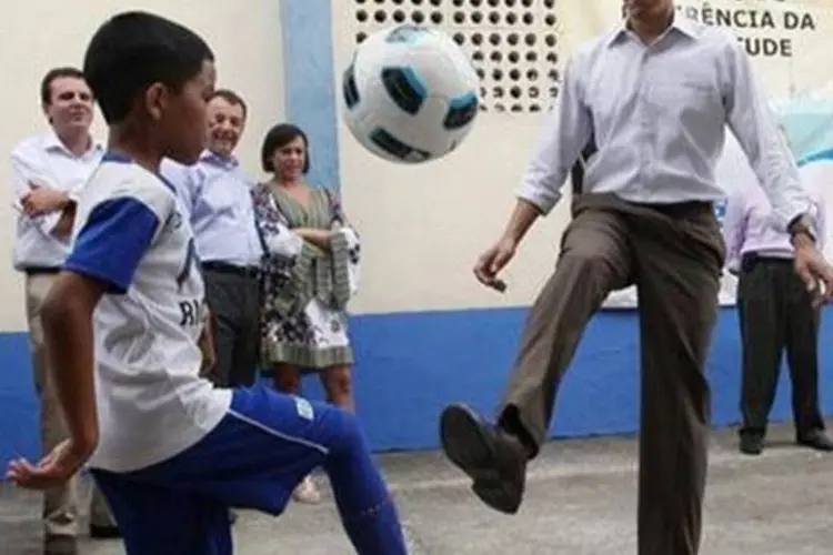Obama bate bola com alunos de escola de futebol da Cidade de Deus (Reuters)