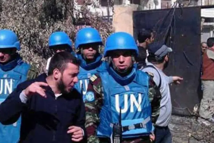 Imagem da Shaam News Network mostra os observadores da ONU no distrito de Khalidiya, em Homs (AFP)