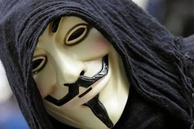 Manifestante do movimento 'Ocupem Wall Street' exibe máscara do protagonista do filme 'V de Vingança', no parque Zuccotti, em Nova York (Timothy A. Clary/AFP)